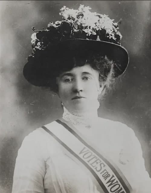 Kitty Marion in a wide feathered hat, wearing a Votes for Women sash, around 1910