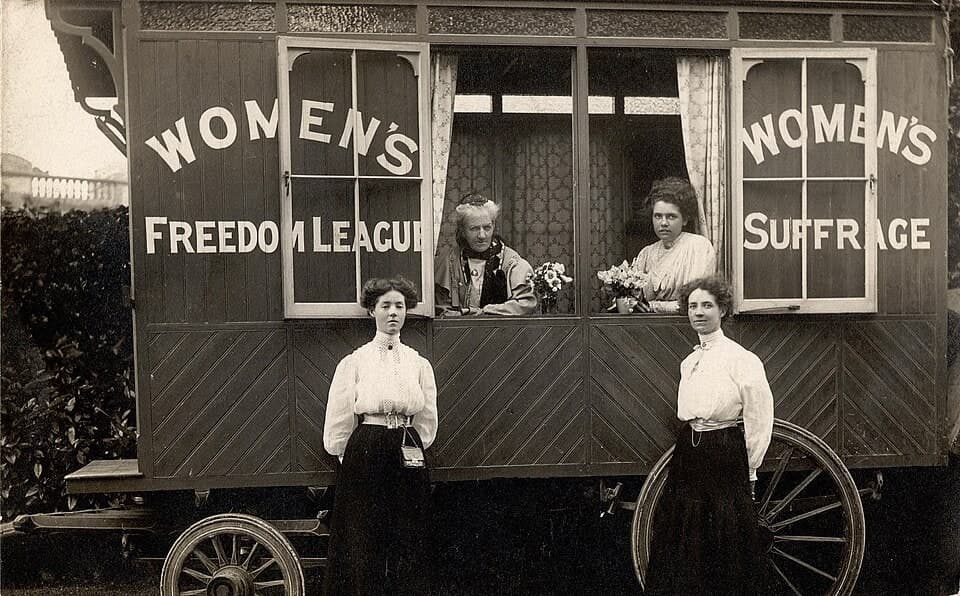 Women's Freedom League campaigners standing beside their horse-drawn caravan on a suffrage tour